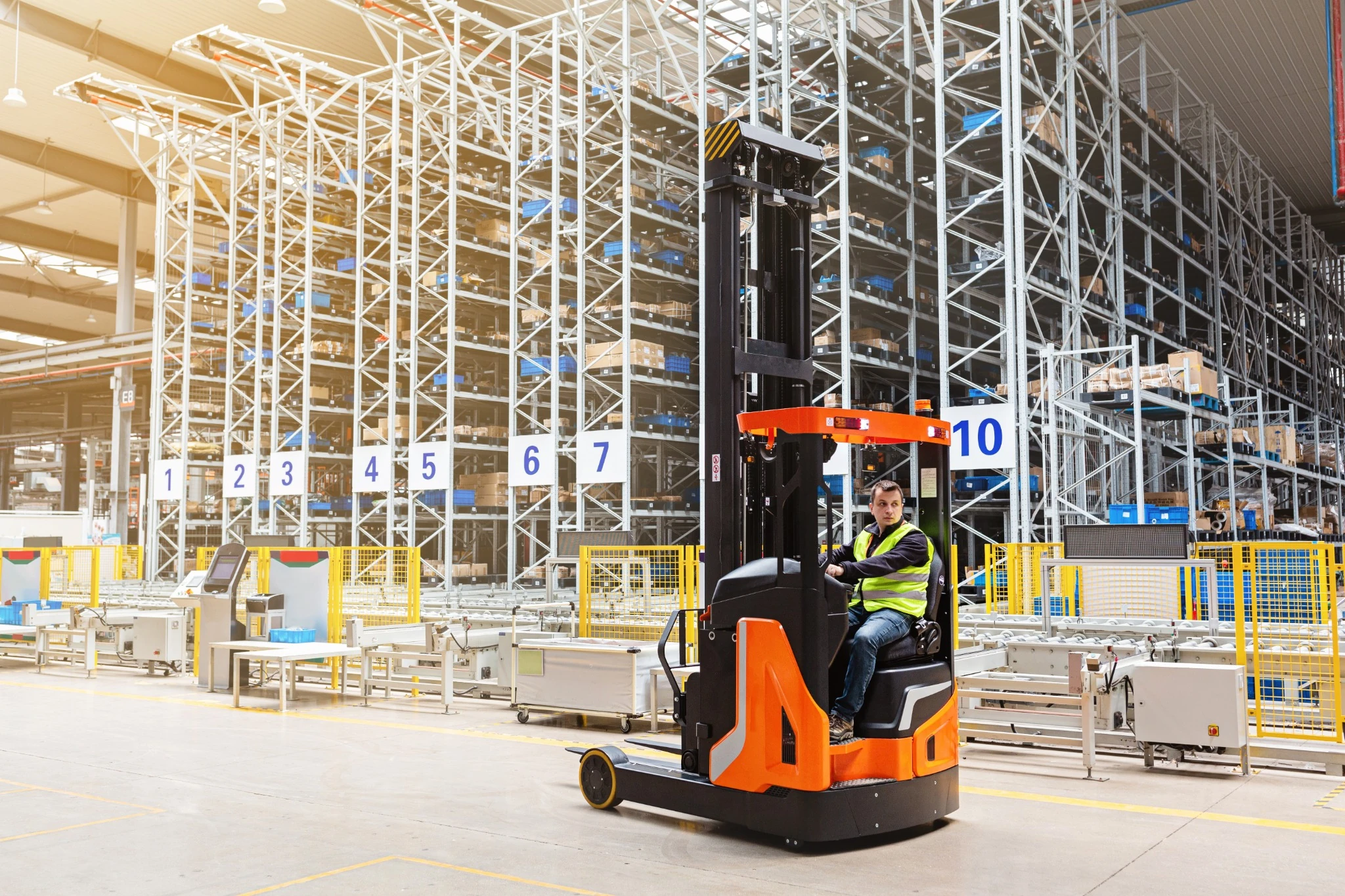 A warehouse operator drives a reach truck lift inside a high-density racking system in Ontario, Canada.